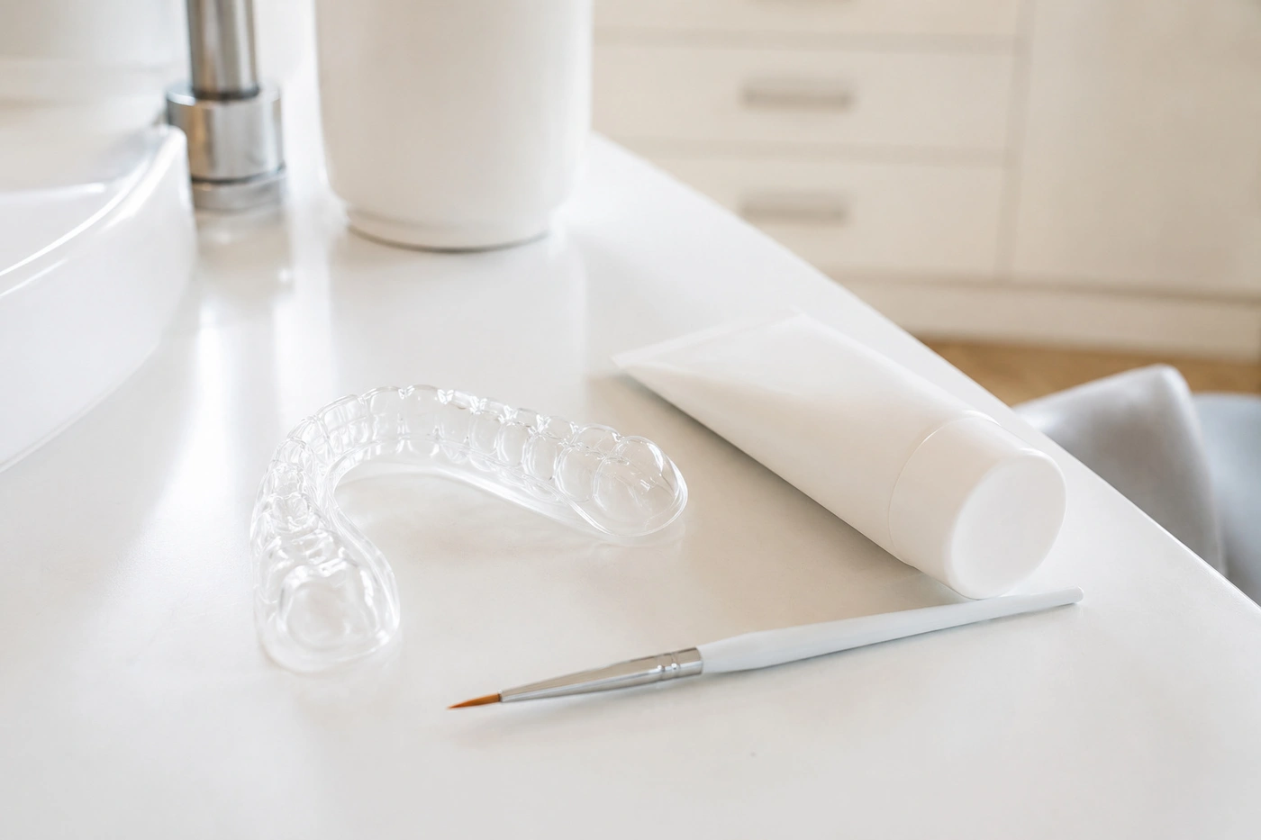 Zähne aufhellen in Offenbach – Bleaching-Schiene, Gel-Tube und Pinsel auf weißer Fläche.